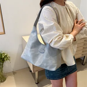 Silbergraue Hobo-Achseltasche mit Metallic-Textur in einem Lifestyle-Innenraum gezeigt