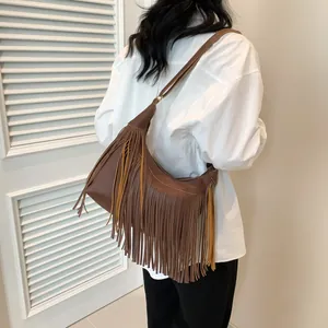 Détail d'un sac hobo marron avec des franges bohèmes et une texture en cuir grainé