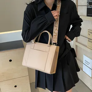 Détail du cabas en cuir beige avec une large bandoulière à motifs pour femme