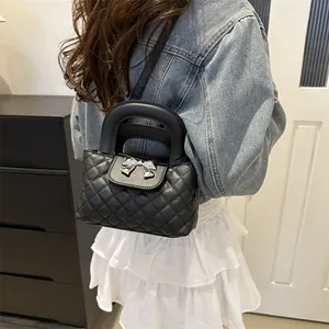 Detail of black quilted handbag featuring a silver bow buckle and elegant metal hardware