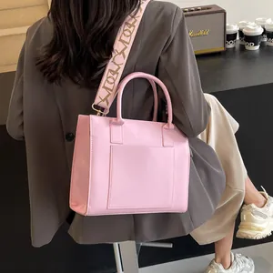 Détail du sac cabas rose en similicuir avec bandoulière tissée large et poignées robustes