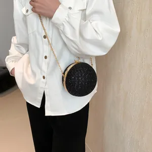 Detailansicht der runden schwarzen Glitzer-Clutch mit goldenem Metallrahmen und Kette