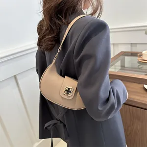 Minimalist beige hobo bag for women with clover magnetic clasp shown on shoulder