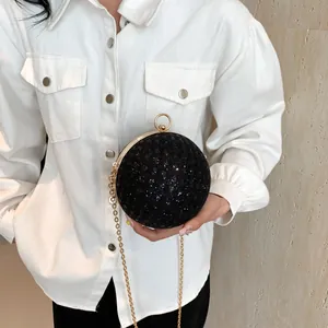 Nahaufnahme der schwarzen Kugel-Abendtasche mit Pailletten und goldenem Ringgriff