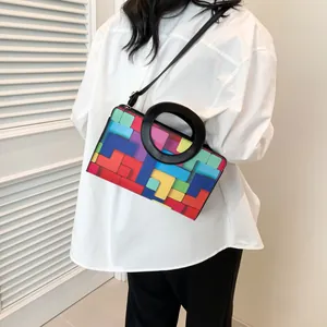 Detail of colorful geometric pattern handbag with round handle and adjustable strap