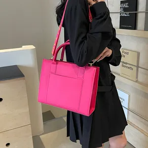 Détail du sac cabas rose fuchsia avec large bandoulière jacquard porté par un mannequin