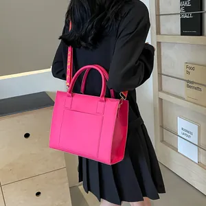 Détail du sac cabas fuchsia avec bandoulière à fleurs et finition en cuir brillant