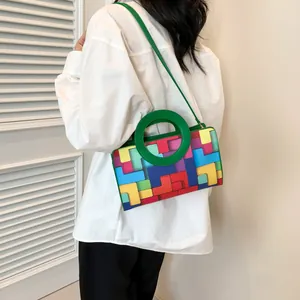 Fashionable geometric color-block shoulder bag with green circular handle and crossbody strap