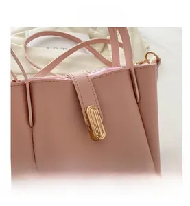 Vue détaillée d'un sac seau rose en cuir avec fermoir ovale doré et fine bandoulière