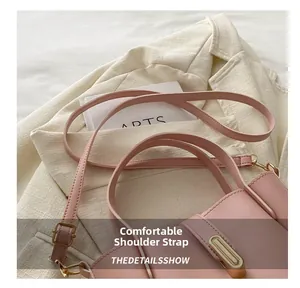 Gros plan sur la bandoulière réglable en cuir avec boucle dorée du sac seau rose élégant