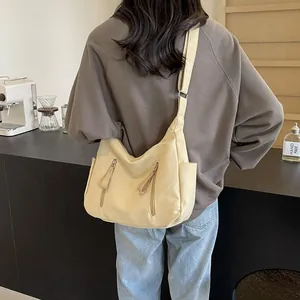 Minimalistische beige canvas crossbodytas met dubbele ritsen en verstelbare schouderriem