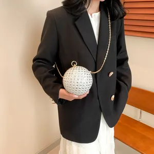 Nahaufnahme einer glitzernden silbernen Kugeltasche mit Strass und goldener Kette
