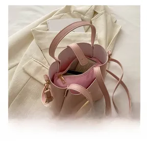 Détail du sac seau en cuir rose clair avec pochette montrant sa grande capacité