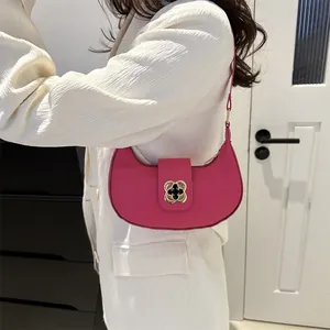 Chic rose red crescent shoulder bag with golden flower clasp on white blazer outfit