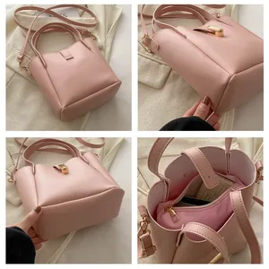 Vue détaillée du sac seau rose avec pochette intérieure, bandoulière et fermoir doré
