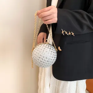 Detailaufnahme der kugelförmigen Abendtasche mit Pailletten und goldener Schulterkette