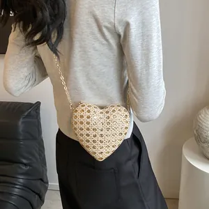 Gros plan du sac de soirée en forme de cœur avec strass et fine bandoulière dorée