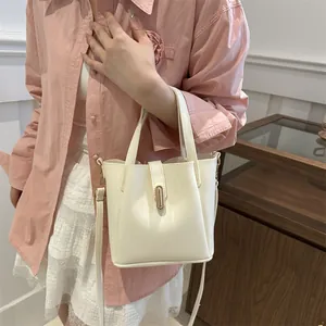 Détail d'un sac seau blanc crème avec fermoir doré et bandoulière réglable pratique