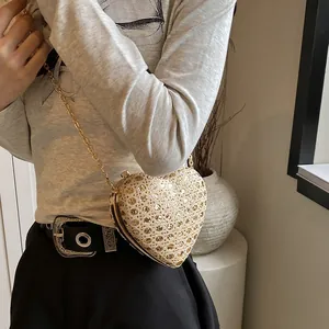 Détail du sac de soirée doré en forme de cœur avec paillettes et fine bandoulière