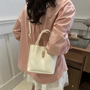 Vue détaillée du sac seau blanc crème avec boucle dorée et bandoulière en cuir