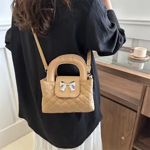 Quilted khaki tote bag with a metallic bow buckle and adjustable shoulder strap