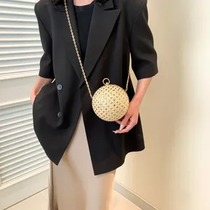 Sphärische geflochtene Umhängetasche mit Goldkette am Modell mit schwarzem Blazer