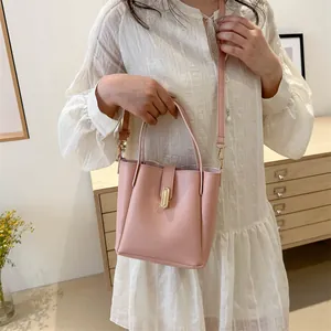 Détail du sac seau rose avec fermoir en métal doré et bandoulière en cuir amovible