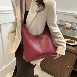 Vintage bordeauxrote Leder-Hobo-Tasche getragen zu beigem Blazer und braunem Rock
