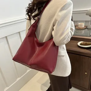 Detail der weinroten Hobo-Tasche aus Leder mit weicher Textur und Schultergurt