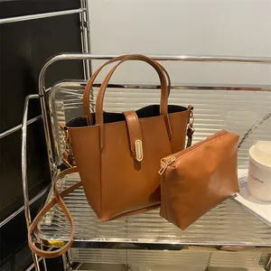 Détail du sac seau caramel avec fermoir doré et pochette zippée intérieure assortie