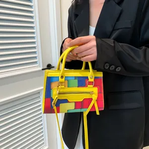 Colorful geometric patchwork crossbody bag with yellow handle and long tassel charm
