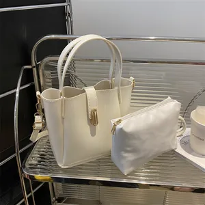 Détail de l'ensemble sac seau blanc avec ferrures dorées sur une étagère en acrylique