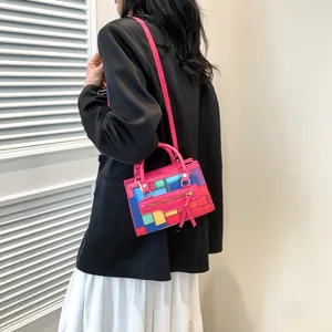 Detail of color-blocked crossbody bag with tassels and gold zipper accessories