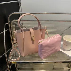 Sac seau rose avec pochette intérieure et bandoulière dorée réglable sur étagère