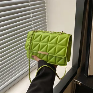 Dettaglio borsa trapuntata verde neon con tracolla a catena dorata e fibbia in metallo