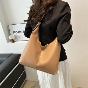 Seitenansicht der hellbraunen Hobo-Tasche mit matter Ledertextur und breitem Schultergurt