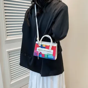 Fashionable crossbody bag featuring geometric color-block print and tassel detail shown on model