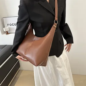 Braune Hobo-Tasche aus Leder mit schwarzem Blazer und goldenen Metallbeschlägen