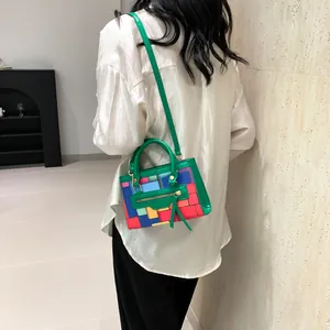 Detail shot of a colorful geometric patchwork crossbody bag worn by a model in soft light
