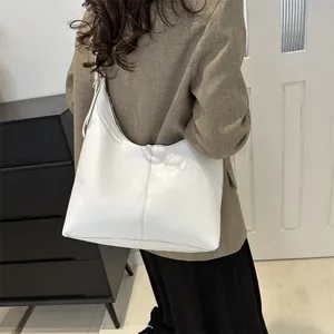 Detailansicht der minimalistischen weißen Hobo-Tasche aus Leder, über der Schulter getragen