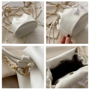 Detail der cremefarbenen Beuteltasche mit Magnetverschluss und eleganter Satinschleife