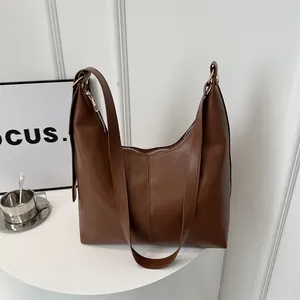 Detail der braunen Leder-Hobo-Tasche mit goldenem Reißverschluss und vertikalen Nähten