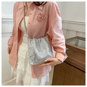 Sparkling silver sequin bucket bag with chain strap styled with a sweet feminine outfit