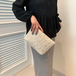 Chic cream woven clutch bag with green vine embroidery and white floral detail