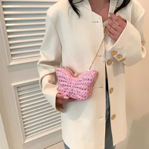 Detalle del bolso de noche mariposa rosa con diamantes de imitación y cadena dorada