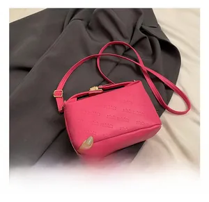 Detail showing bright pink crossbody bag with rich rabbit embossed pattern and gold buckle