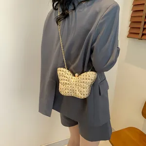 Detalle del bolso de noche con forma de mariposa, lentejuelas doradas y cadena