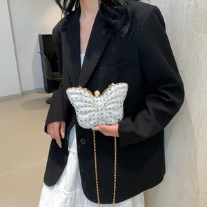 Detalle del bolso de noche de mariposa plateado con diamantes de imitación y cadena