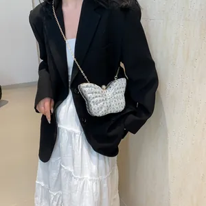 Elegante bolso de mano con forma de mariposa, pedrería brillante y cadena dorada