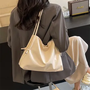 Bolso tote de cuero crema suave en modelo que muestra su caída y gran capacidad de carga